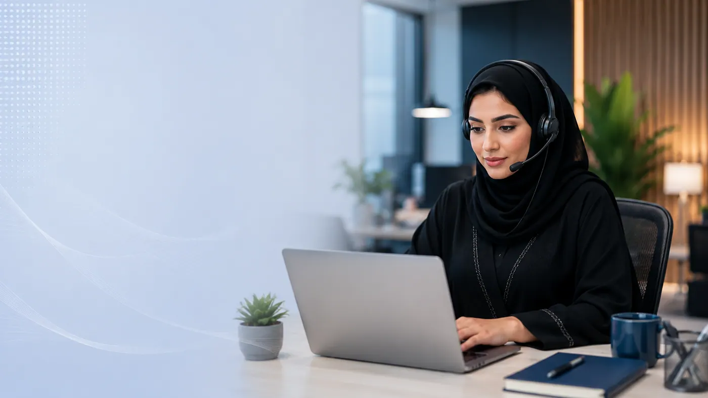 موظفة دعم سعودية محجبة بheadset أمام حاسوب محمول